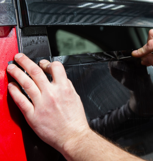 man installing black window tint